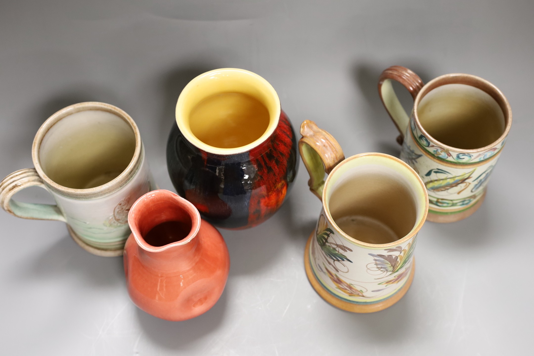 Three Glyn College jugs, a flambé Poole vase and a Burmantoft ‘White’ dimpled vase no. 989, tallest 16.5cm